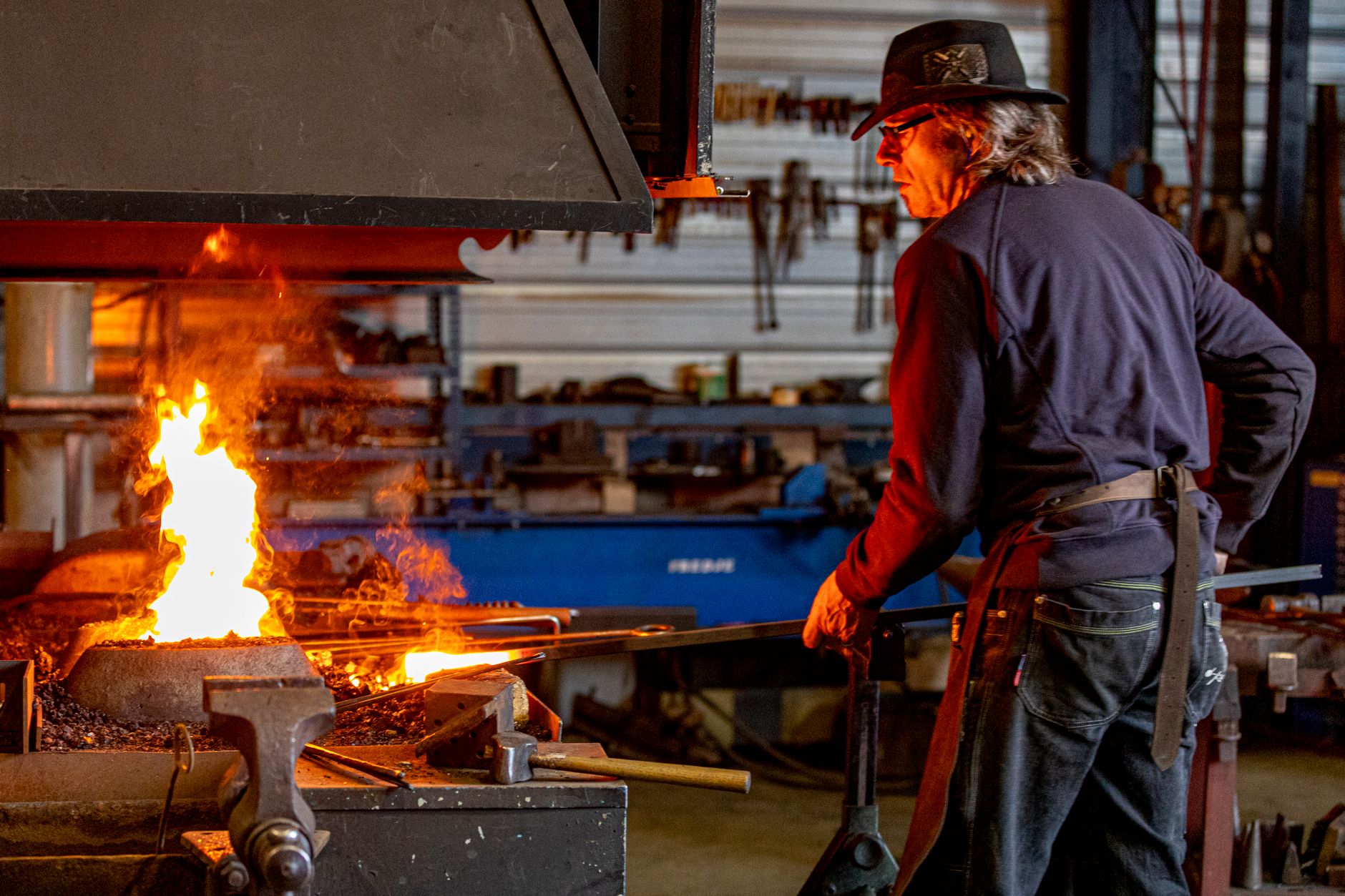 Welding instructor demonstrating torch technique to trainees in a college shop classroom
