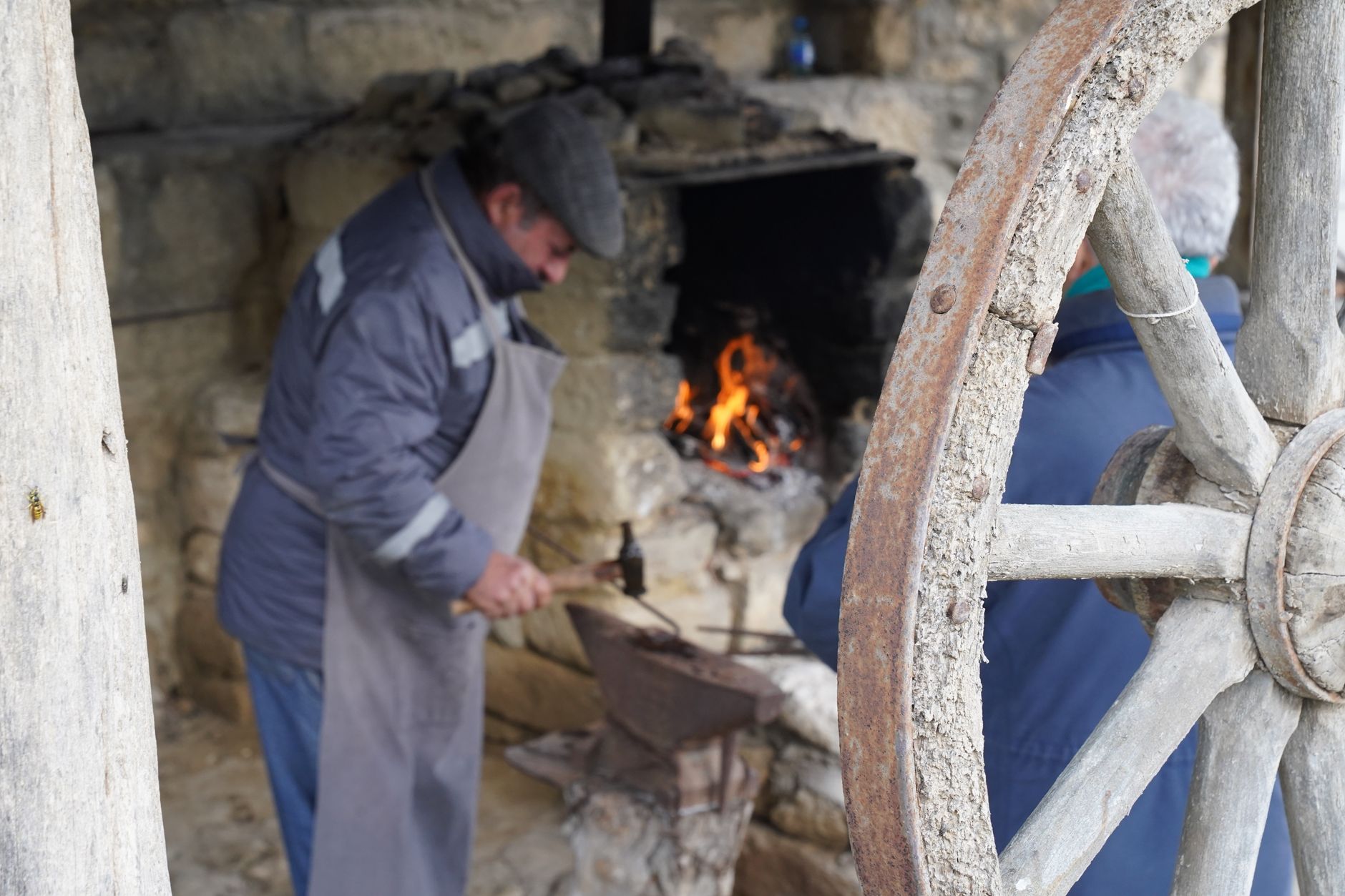 A blacksmith working at a coal forge