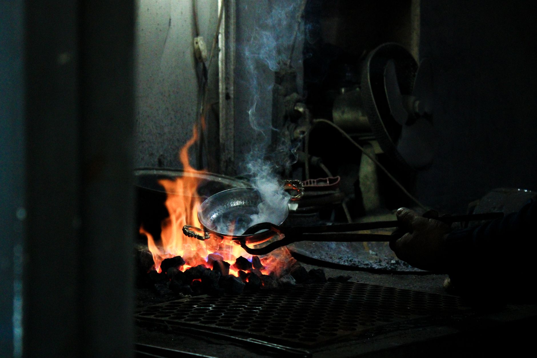 Blacksmith shaping tongs on an anvil