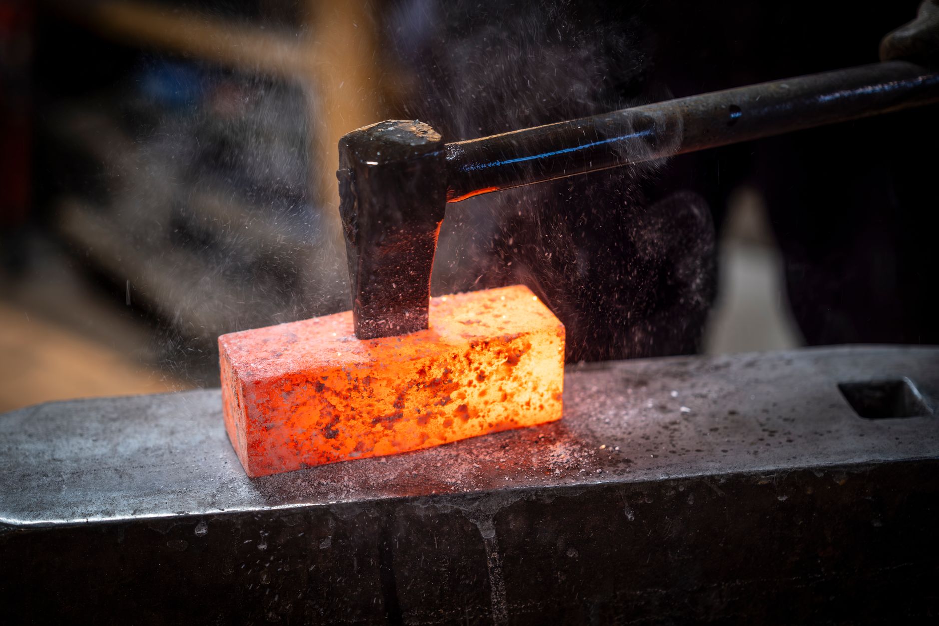 A blacksmith hammers a glowing orange blade at an anvil inside a small rural forge