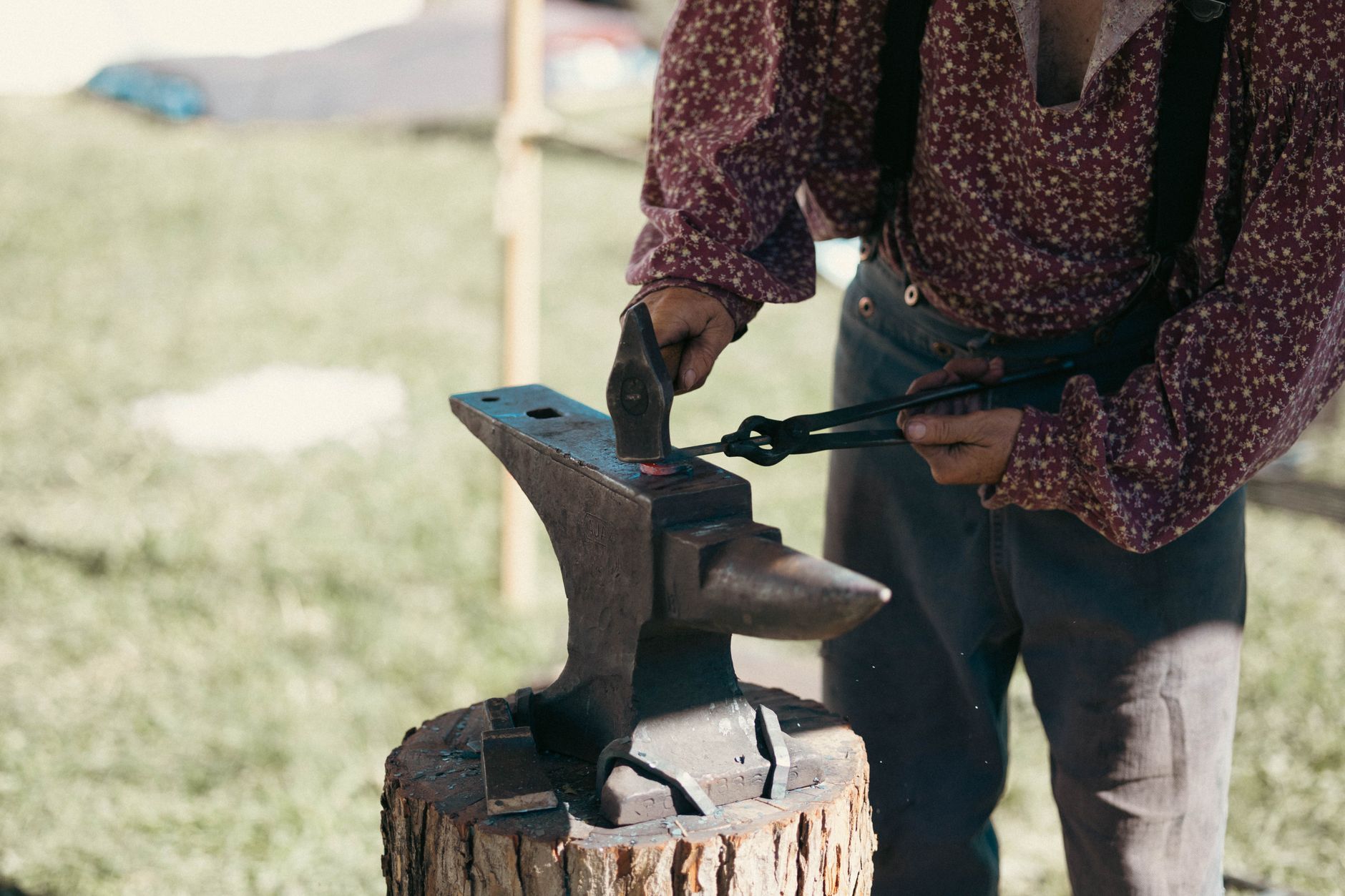 Blacksmith guiding a participant in forging a knife