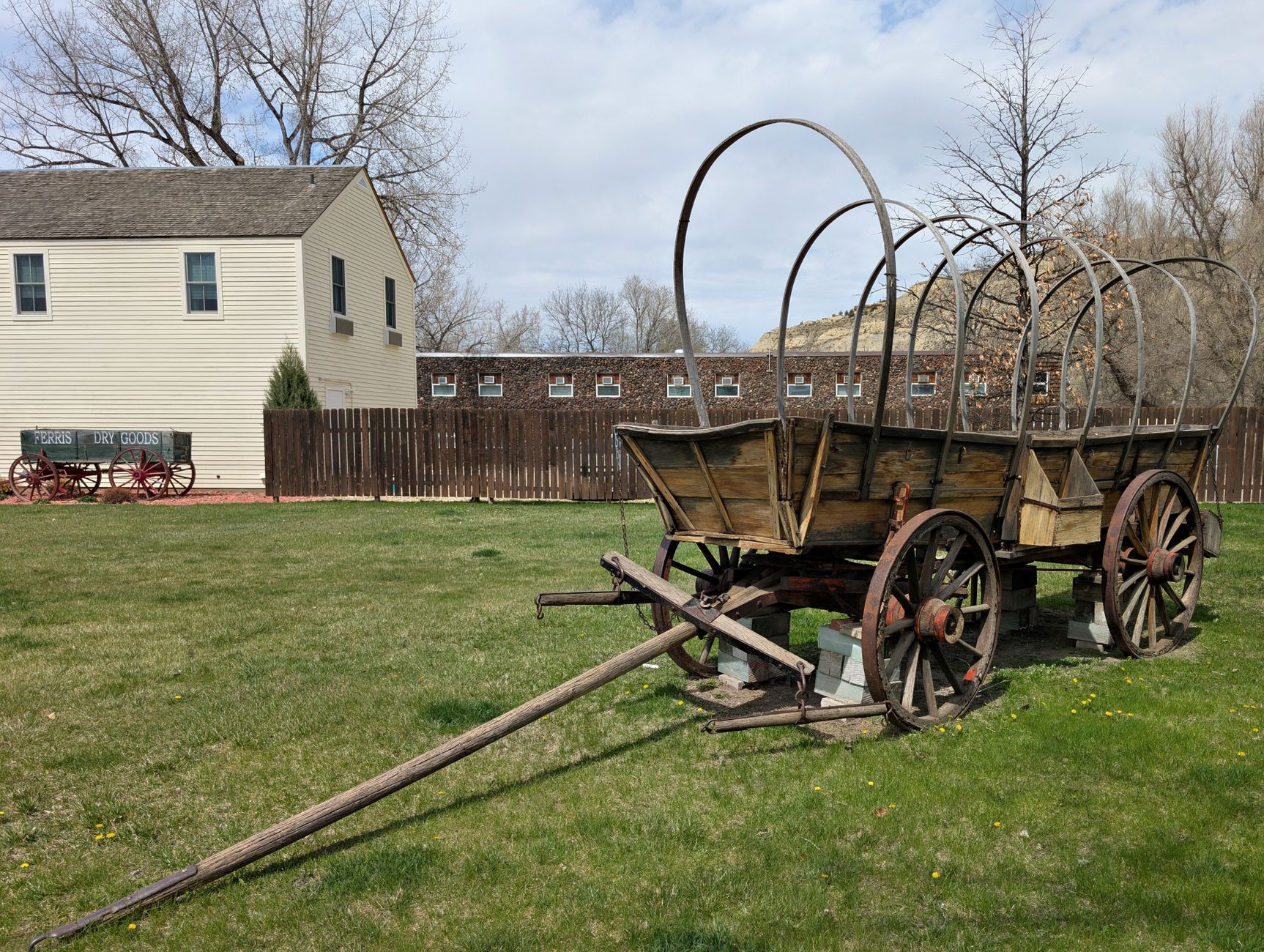 A beginner blacksmith practices hammering a glowing metal bar at an outdoor forge station during a living history demonstration